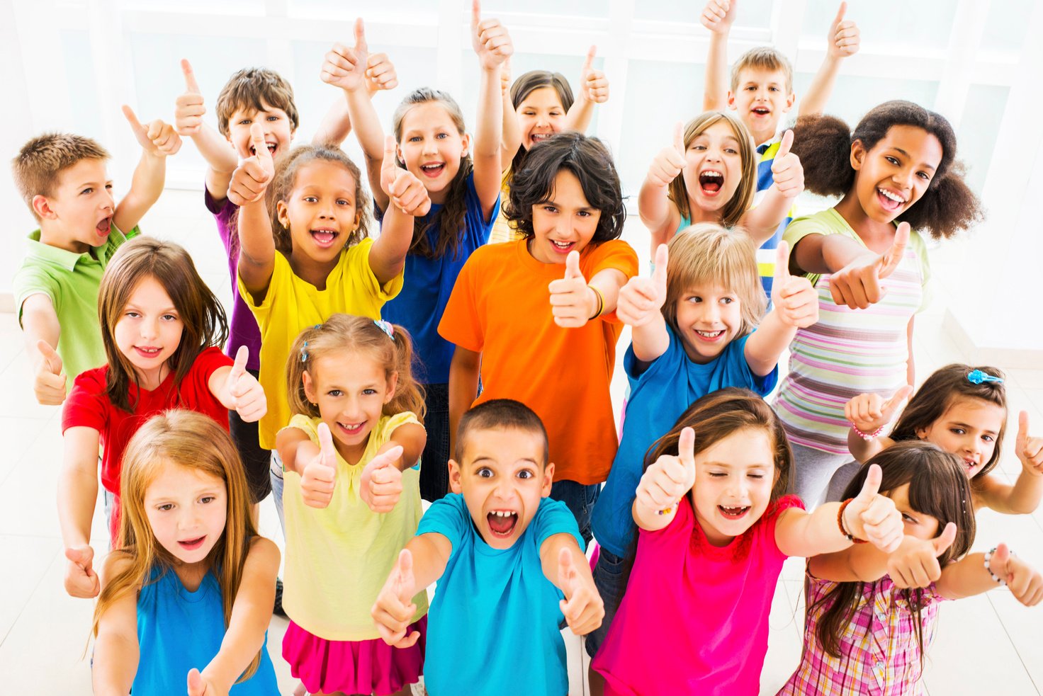 Group of children showing thumbs up.